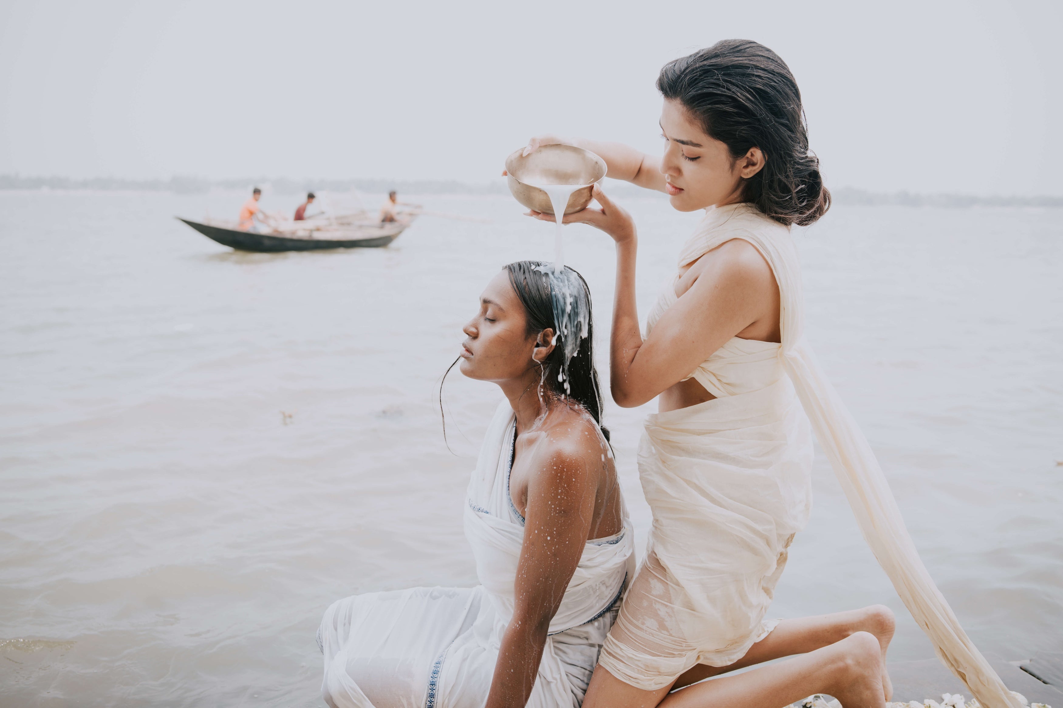 Indian woman practicing traditional Indian bathing rituals next to a river.