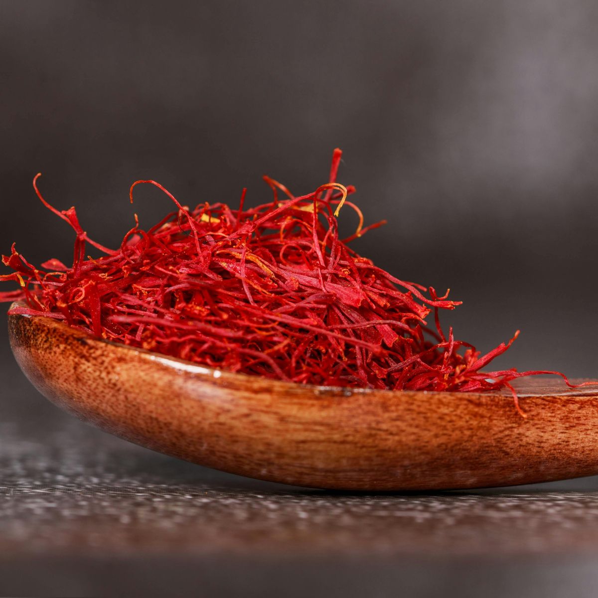 The luxurious spice saffron in a wooden spoon, used for it's skin healing benefits in UMM's Radiance Masque.