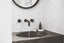 Luxurious bathroom with water running from sync and UMM Skincare products on the counter.