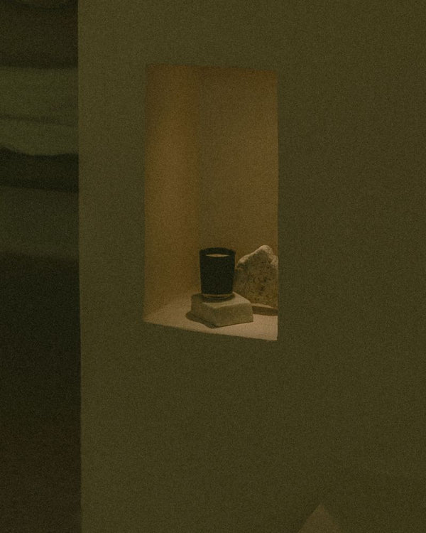 UMM Skincare scented candle providing ambiance in the bathroom.