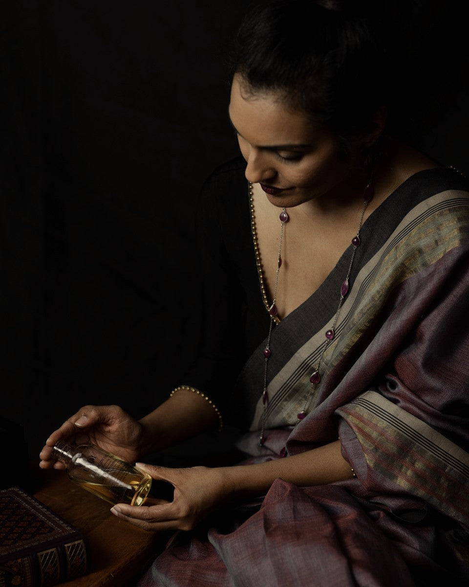 Anisha Vinjamuri holding a bottle of golden oil